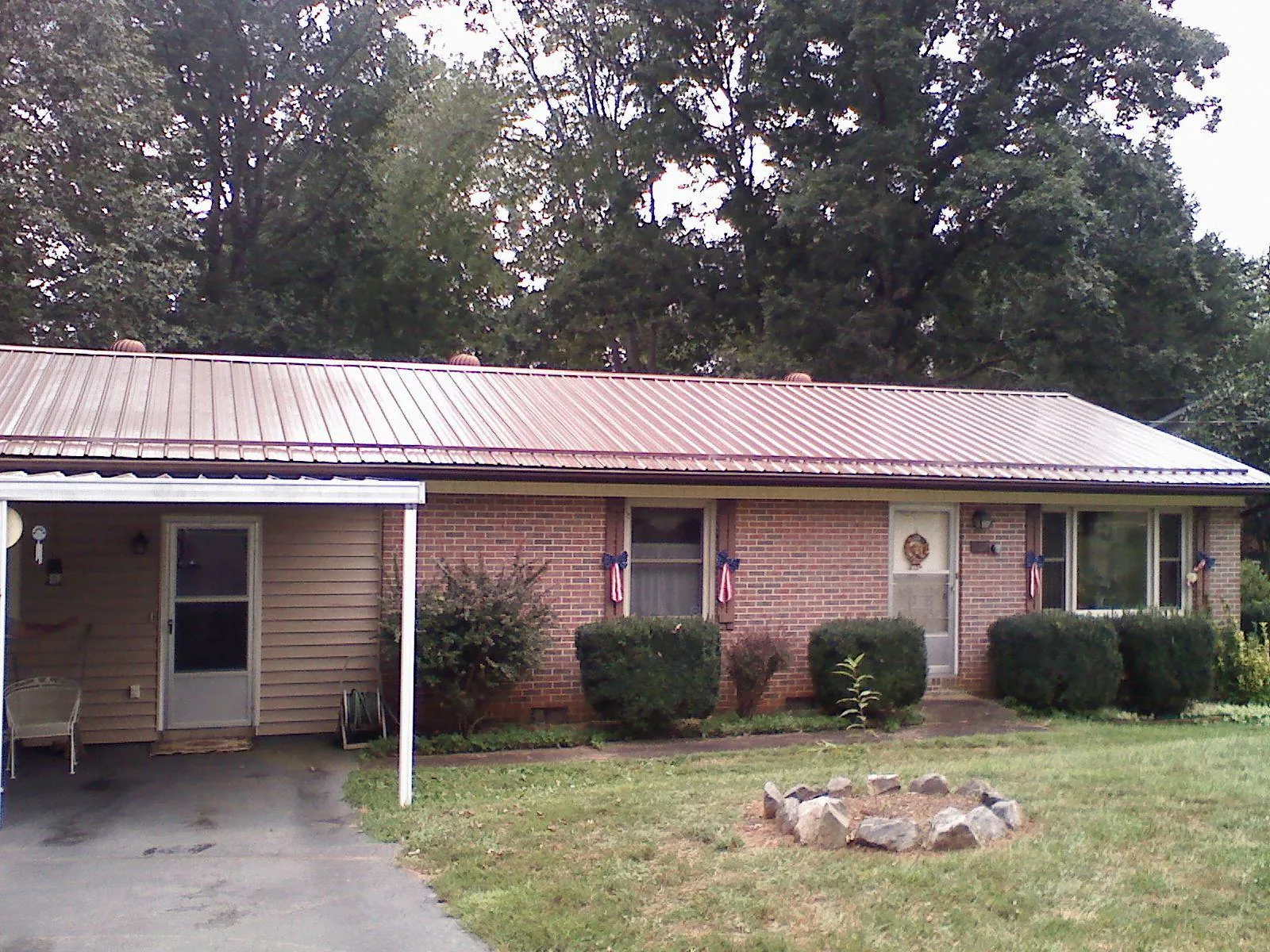Bronze metal roof and carport on a brick ranch home — Roof Repair work by our crew in Colon